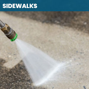 Close up of someone power washing a sidewalk